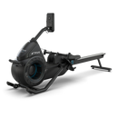 A black and sleek rowing machine with a digital monitor, sturdy frame, and footrests, displayed on a white background. The machine features the brand name TRUE on its side.